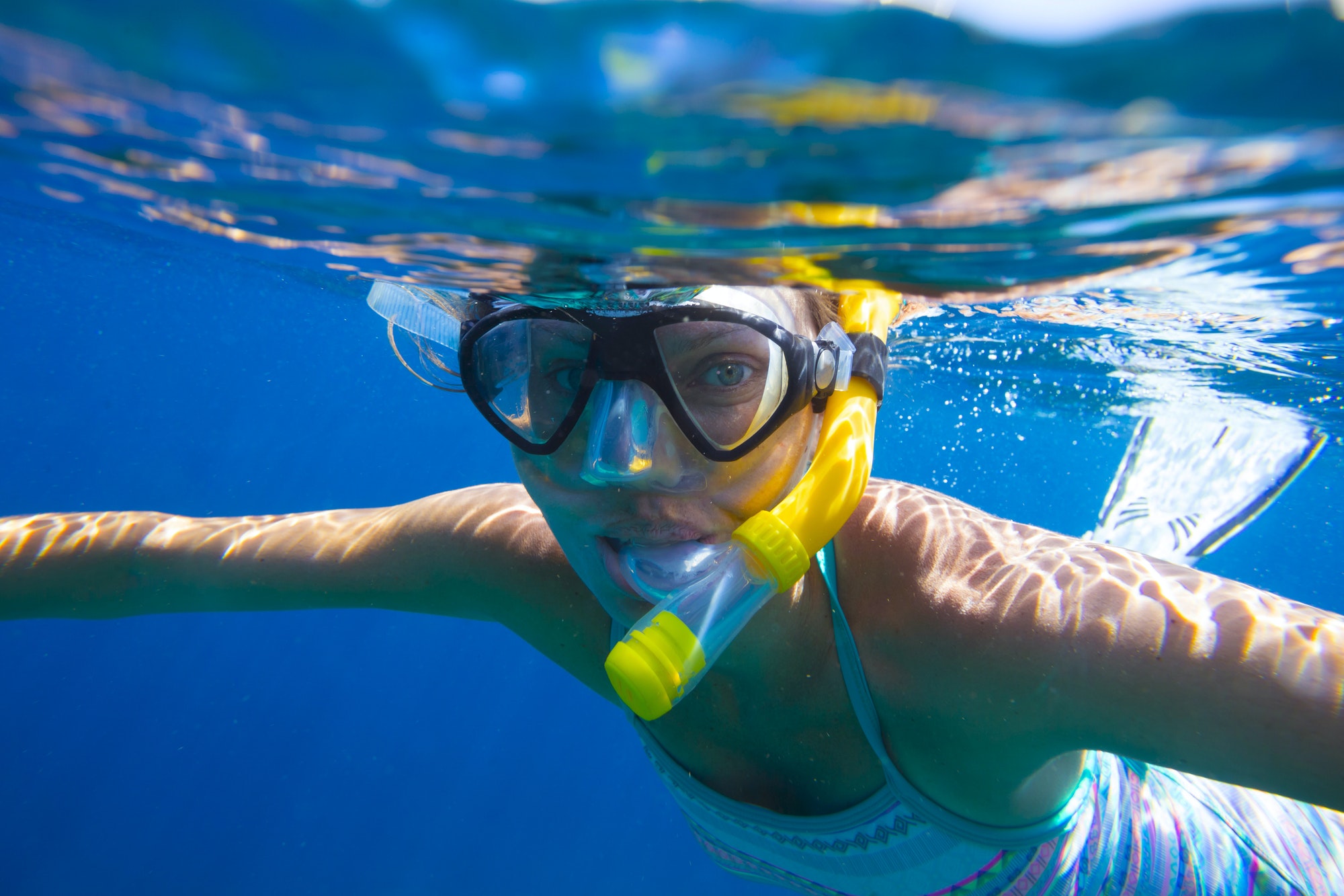 Young women is snorkeling in the tropical water